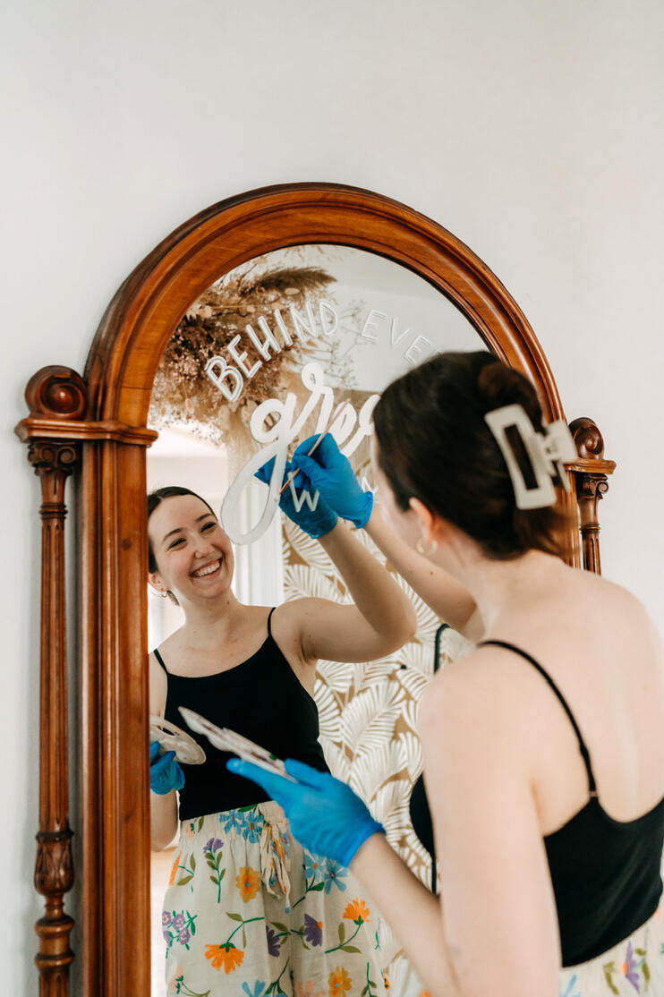 Das Bild zeigt Antonia Hafner-Guth beim Bemalen eines großen Spiegels.